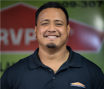 a man in front of a green SERVPRO background