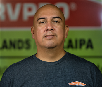 a man in front of a green SERVPRO background